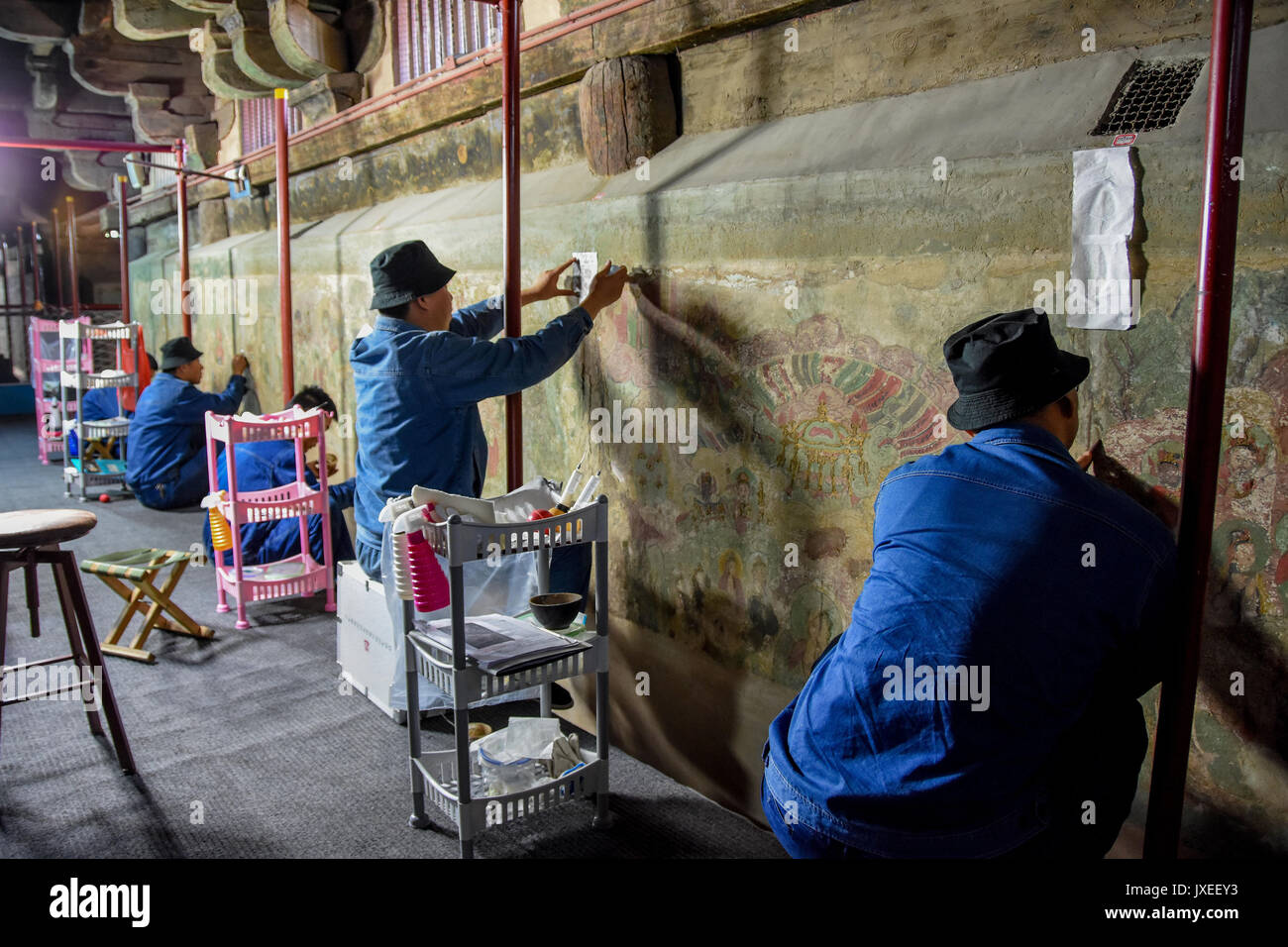 Zhengding, Hebei Provinz Chinas. 15 Aug, 2017. Experten ein altes Wandbild an Longxing Tempel in Zhengding, im Norden der chinesischen Provinz Hebei, Aug 15, 2017 wiederherstellen. Die Restaurierung und Erhaltung der Werke des Buddhistischen Wandmalereien von der Ming Dynastie (1368-1644), belegen 400 Quadratmeter im Gange sind. Credit: Chen Qibao/Xinhua/Alamy leben Nachrichten Stockfoto