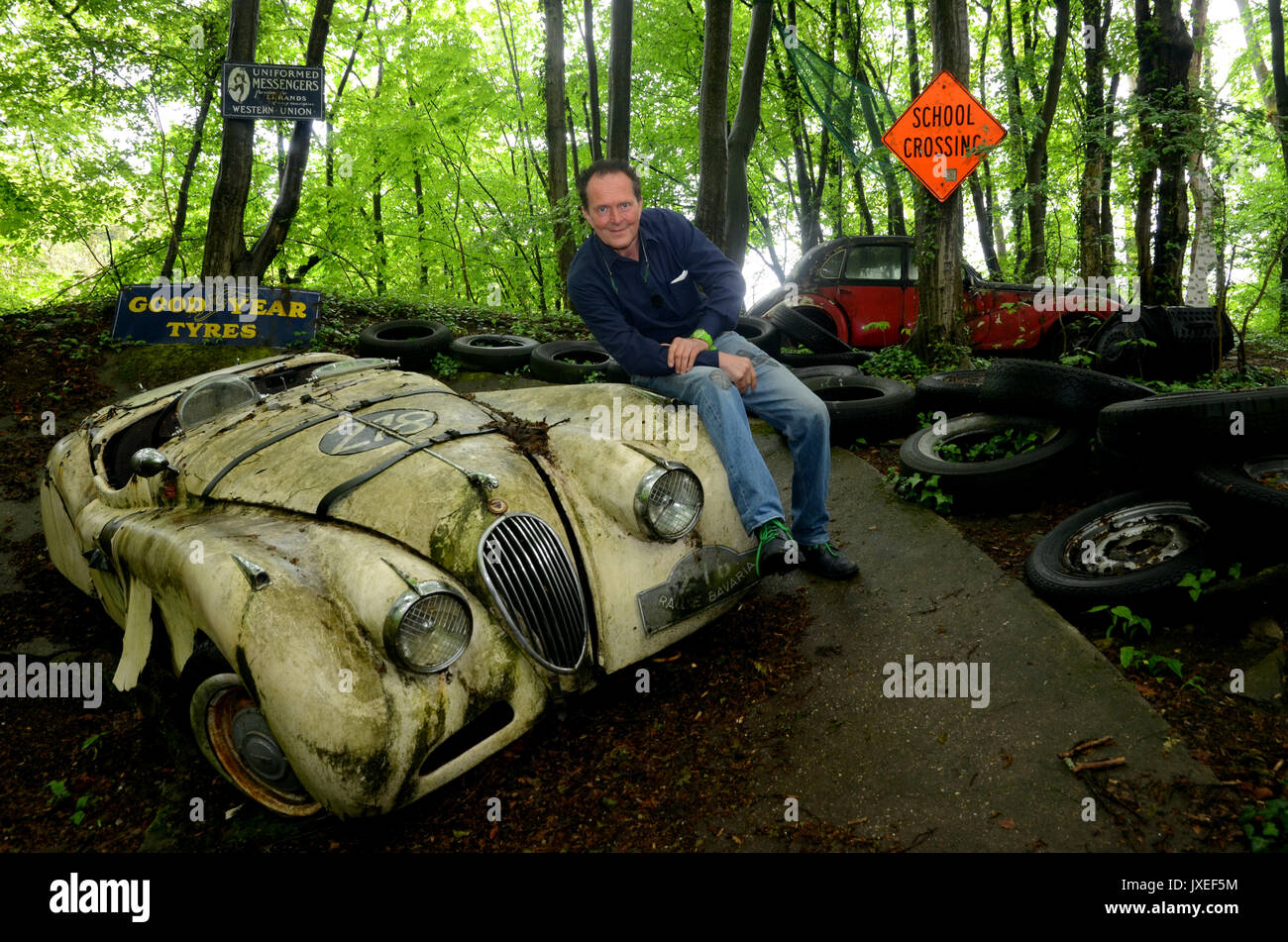 Mettmann, Deutschland. 27 Apr, 2014. Classic Car Spezialist Michael  Froehlich sitzt auf seinem Jaguar Rennwagen in seinem Auto Skulpturenpark  in Mettmann, Deutschland, 27. April 2014. 50 Autos sind rot auf Michael  Froehlich