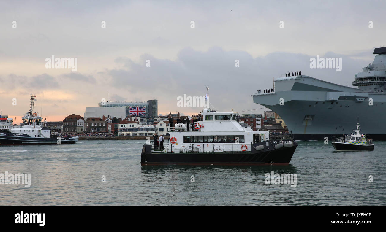 Portsmouth, Großbritannien. 16 Aug, 2017. HMS Queen Elizabeth Ankunft an Ihrem Haus Dock in Portsmouth mit Zuschauer fangen einen Eindruck von 3 Milliarden Pfund Flaggschiff Flugzeugträger der Royal Navy entlang in Portsmouth Harbour passiert. Viele Menschen nahmen es Spots aus den frühen Stunden des Morgens, ein Teil der Geschichte werden. Die Eintragung des Schiffes wurde von einem Flypast der Fleet Air Arm Merlin und Wildcat Hubschrauber begleitet, plus Hawk Jets von 736 NAS von culdrose. Credit: uknip/Alamy leben Nachrichten Stockfoto