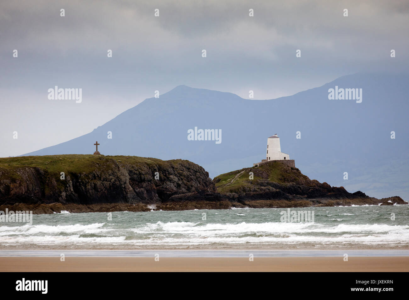 Windigen Sommer Wetter über Ynys Llanddwyn Island oder Llandddwyn Insel mit Twr Mawr Leuchtturm und Drynwen Kreuz sichtbar vor dem Hintergrund der Berge, Rhosneigr, Anglesey, Wales, Großbritannien Stockfoto