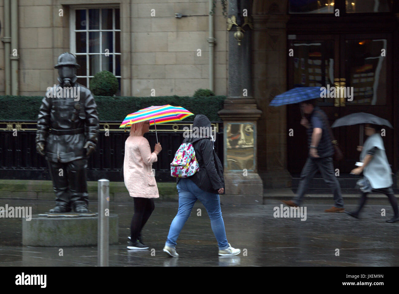 Glasgow, Schottland, Großbritannien. 16 Aug, 2017. Regen im Zentrum von Glasgow's Station 911 Feuerwehrmann Statue als Touristen entdecken Sie die Tatsache, dass es die regenreichste Stadt in Großbritannien. Gerard Fähre / alamy Nachrichten Stockfoto