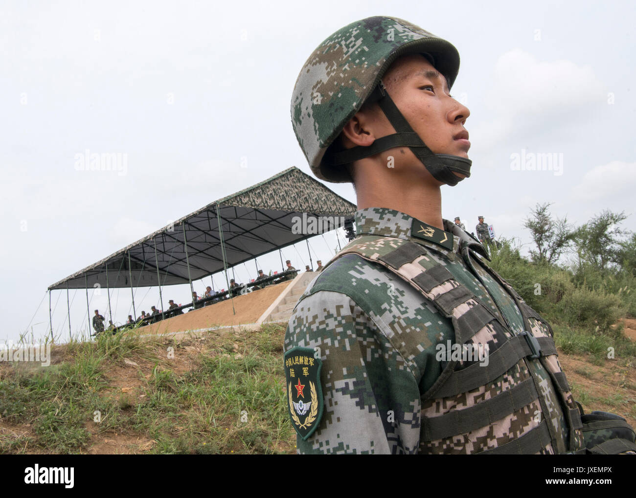 Haichung, China. 16 Aug, 2017. Eine chinesische Volksbefreiungsarmee Soldat steht Wache in der Nähe des VIP-Beobachter stand während eines Angriffs Übung an der Chinesischen Northern Theater Armee Kraft Haichung Camp August 16, 2017 in Haichung, China. Die übung war für den Besuch der US-Generalstabschefs General Joseph Dunford. Credit: Planetpix/Alamy leben Nachrichten Stockfoto