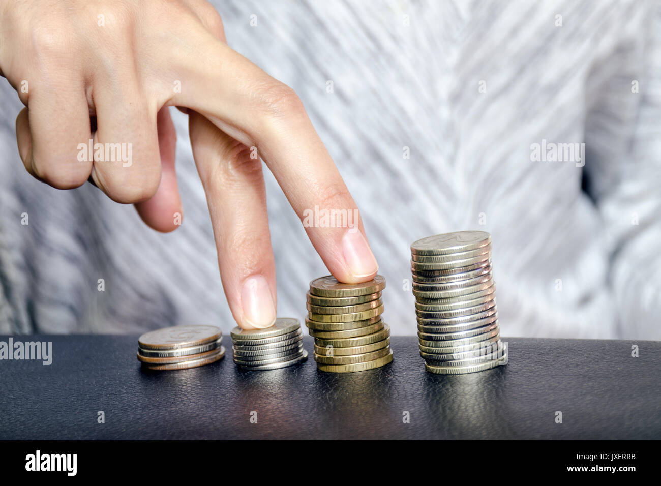 Finger weg auf Stapel von Münzen, die für finanzielle Wachstum und Fortschritt im Geschäft. Das Konzept der Karriere Wachstum und Lohnerhöhungen Stockfoto