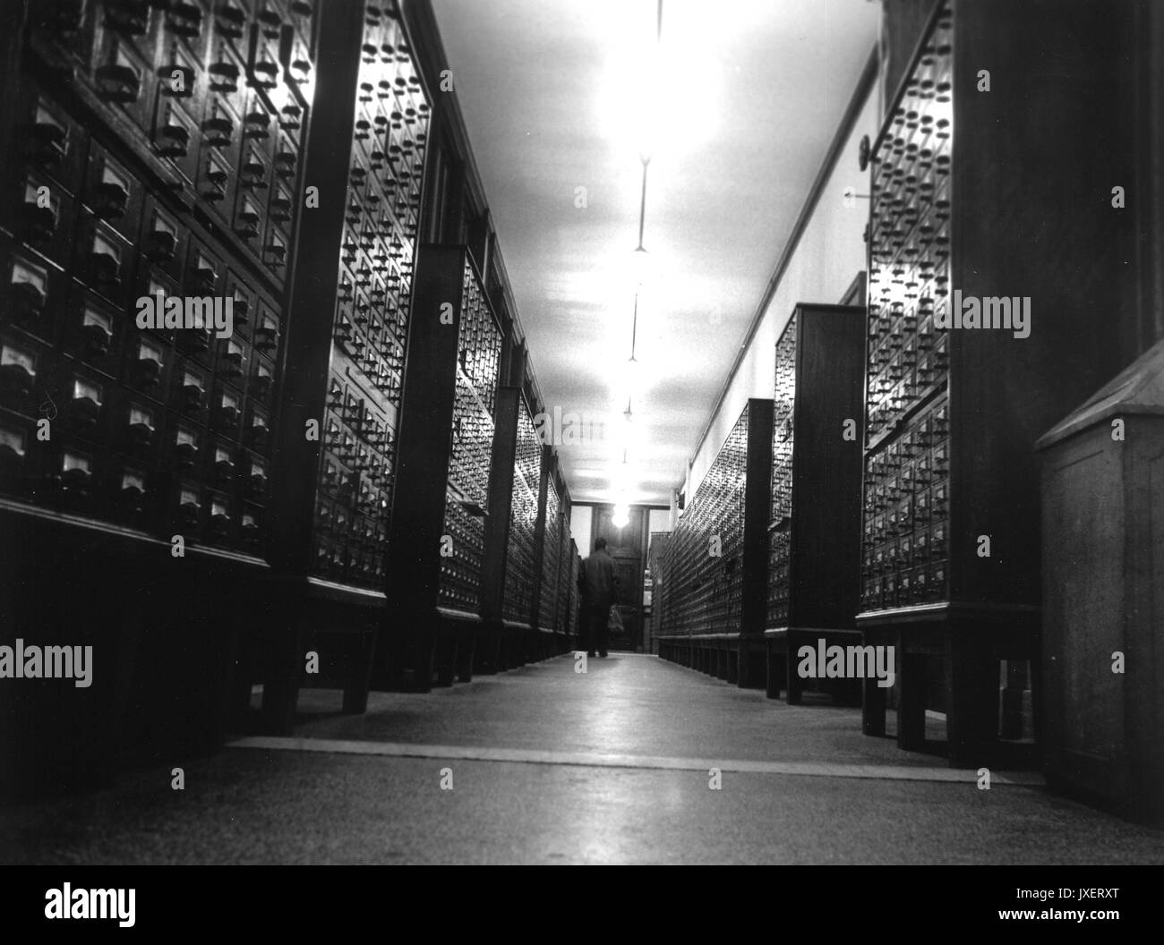 MSE-Bibliothek, die von einer Person durch einen Flur mit zettelkatalogen, 1960 gefüllt. Stockfoto