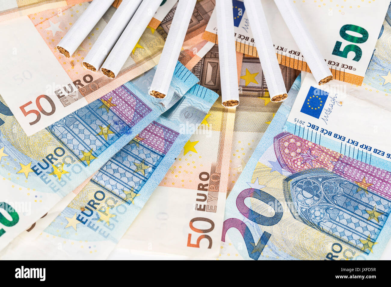 20 und 50 Euro-Banknoten Rechnungen bar mit Zigaretten. Konzept der Kosten für Tabak, Zigaretten. Vordere und obere Ansicht, close-up. Stockfoto