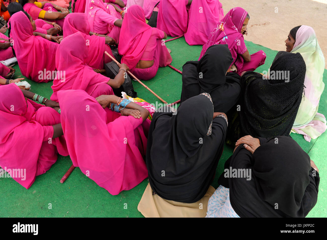 Indien Uttar Pradesh Banda, niedrige Kaste und Kastenlosen Frauen in der Frauenbewegung Gulabi gang der Frauen leader Sampat Pal Devi organisieren und mit bambusstöcken für gleiche Rechte und gegen gewalttätige Polizei oder Männer, Frauen in Rosa von Gulabi gang und schwarz verschleierte muslimische Frauen Stockfoto