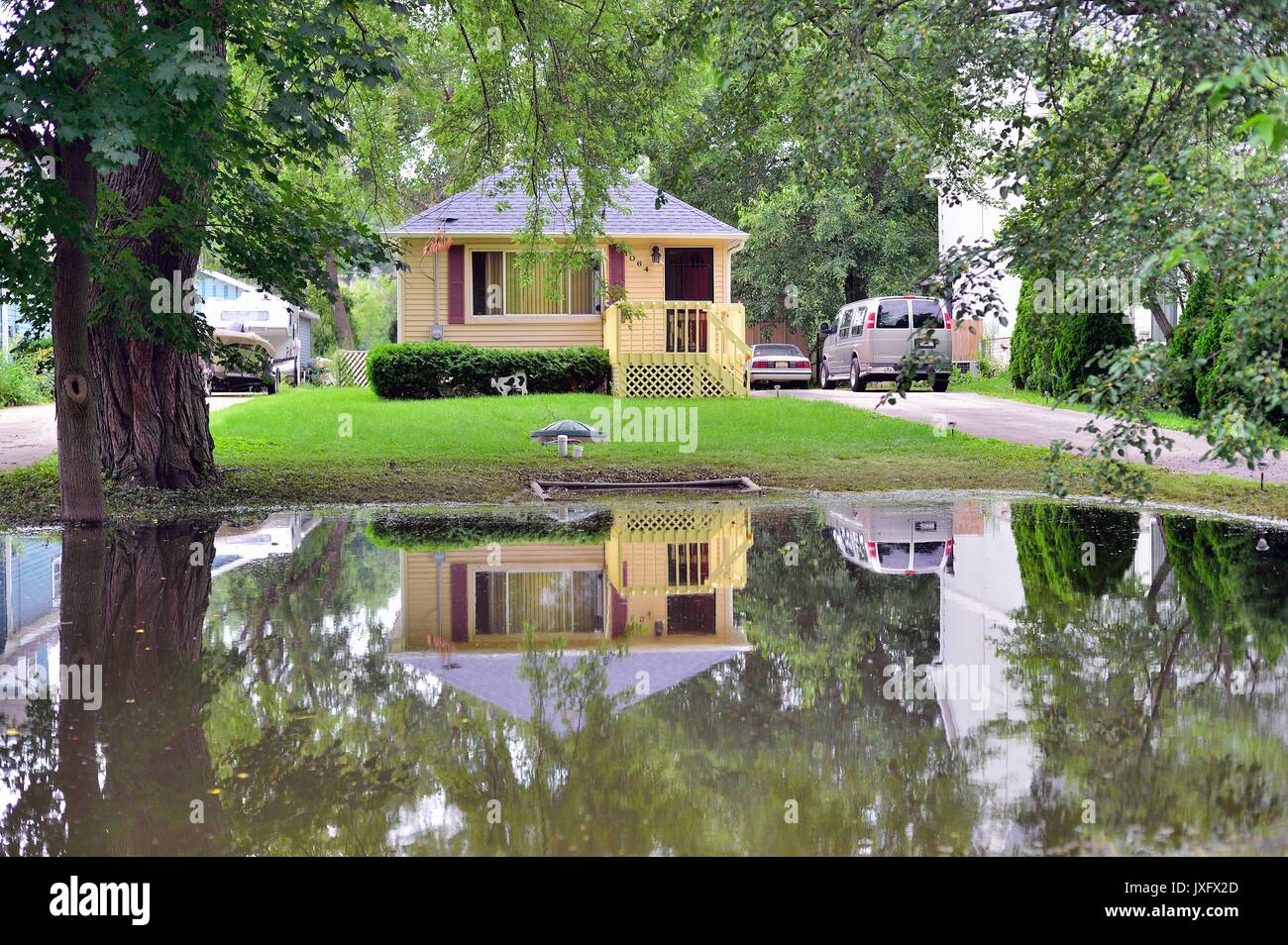 Nach dem Seine Ufer überflutet, die Fox River links ein Restwert pool im Vorgarten eines Hauses während der Hinterhof unter Wasser blieb. USA. Stockfoto