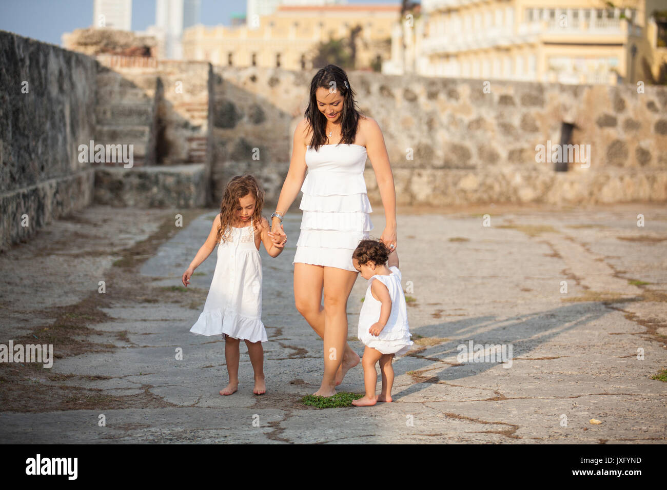 Mutter und ihre Töchter in Weiß zu Fuß entlang der Wand gekleidet Cartagena Stockfoto