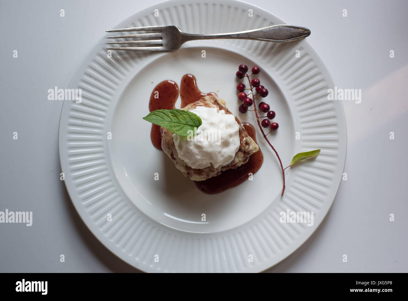 Hausgemachte Chokecherry Sirup über shortcake Dessert mit Sahne und Minze Blatt. Stockfoto