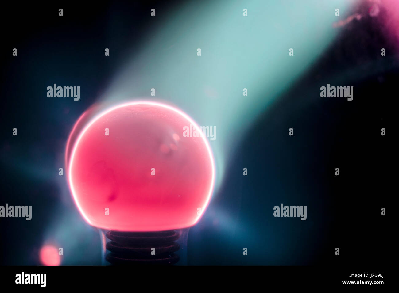 Lit Tesla Coil closeup, mit blauen elektrische Strahlen, Rot, Pink und Lila, schwarzer Hintergrund Stockfoto