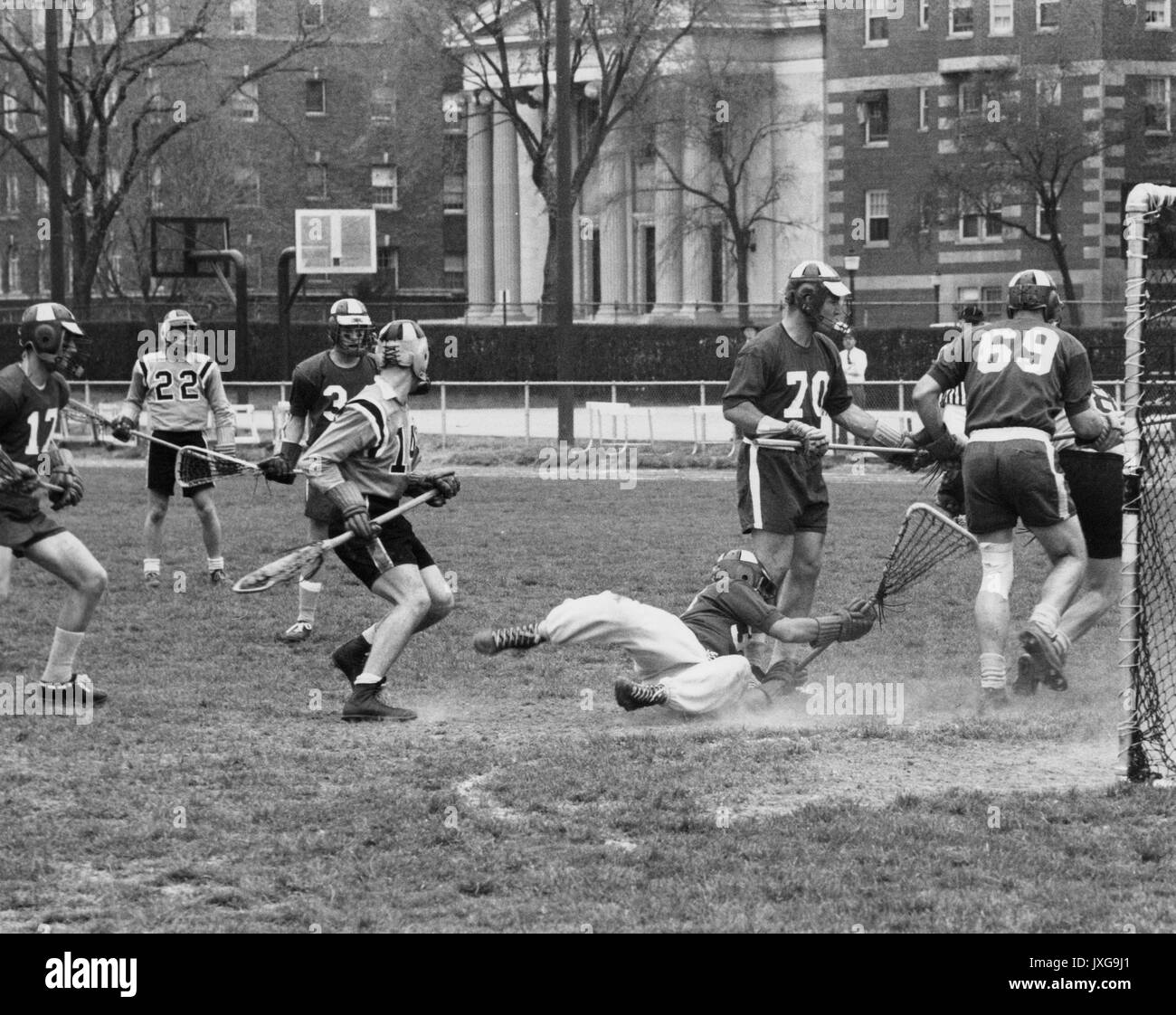 Lacrosse geschossene Tätigkeit während einer unidentifed lacrosse Spiel im Homewood Campus, ein Spieler zu Boden fiel in einer Bemühung, die Kugel zu fangen, 1950er hat. Stockfoto