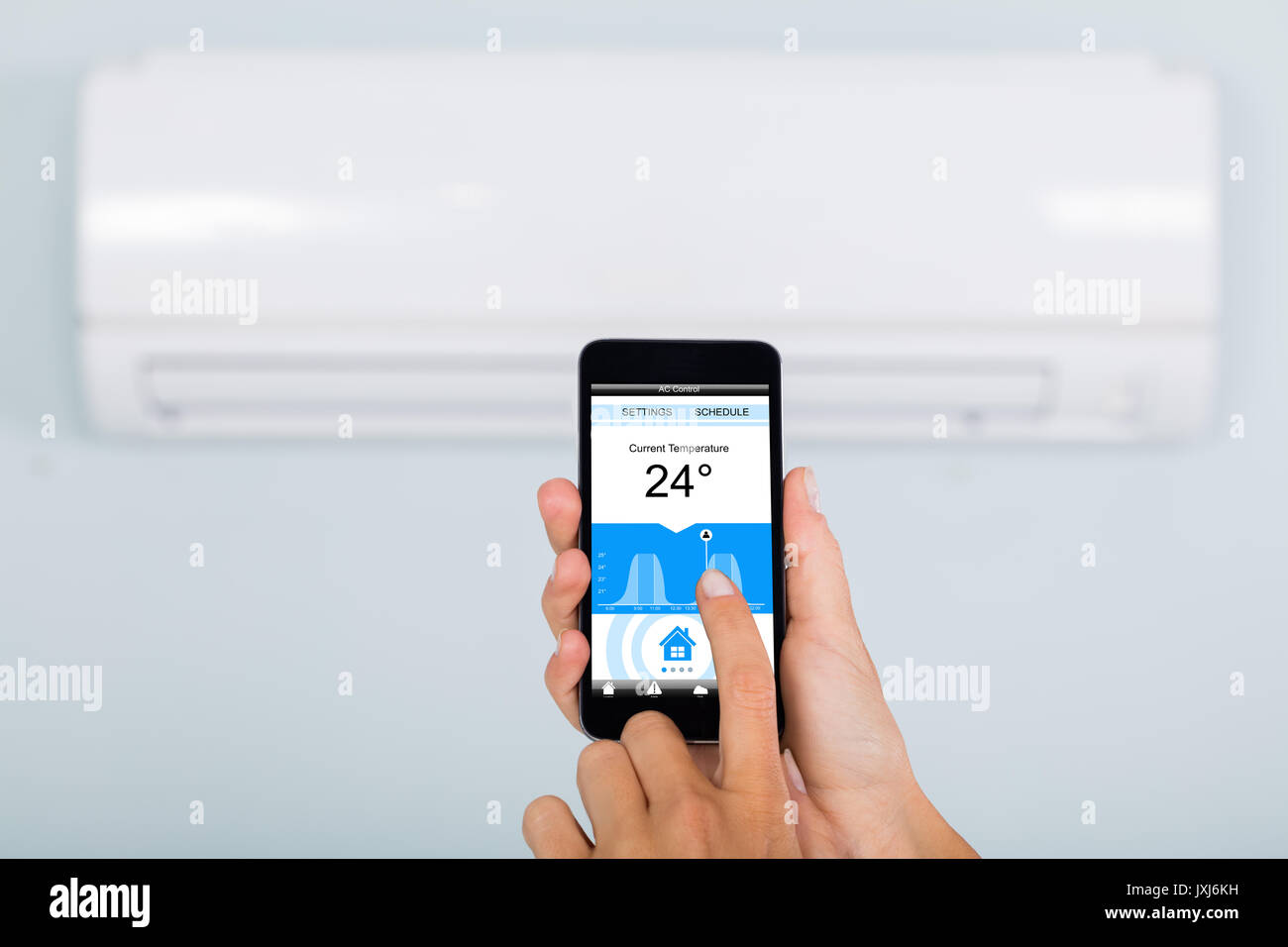 In der Nähe von Frau Hand Einstellung Temperatur der Klimaanlage mit Handy  App zu Hause Stockfotografie - Alamy