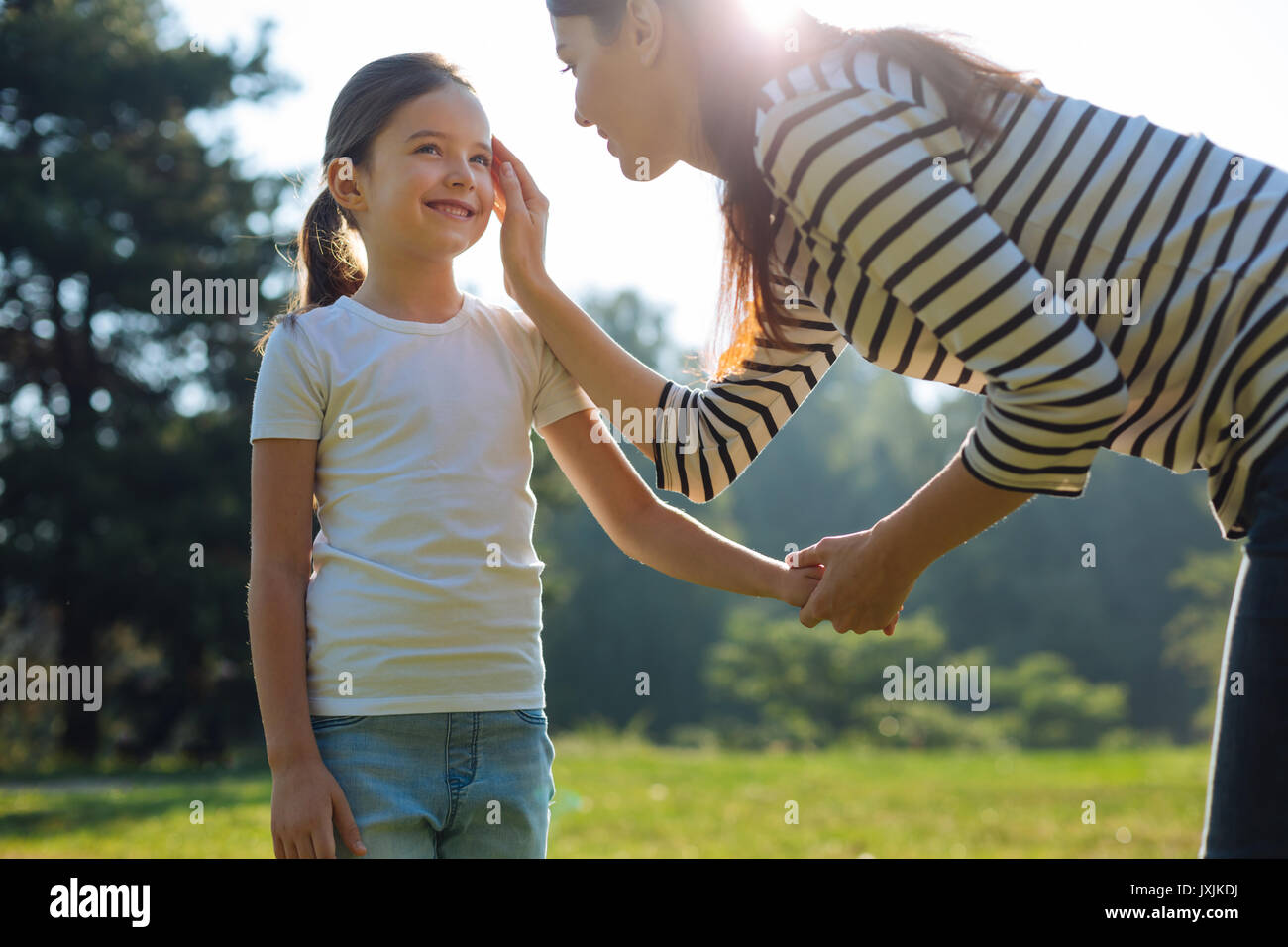 Sanfte Mutter ihre Töchter Wange streicheln Stockfoto