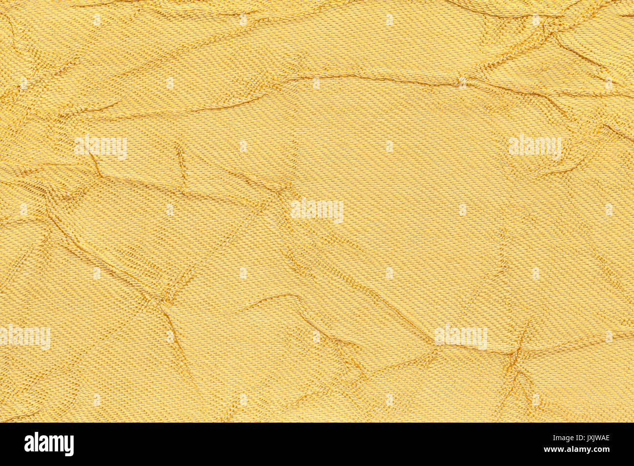 Licht gelb gewellt Hintergrund von einem Textilmaterial. Stoff mit Falten Textur closeup. gerillt glänzende goldene Tuch. Stockfoto