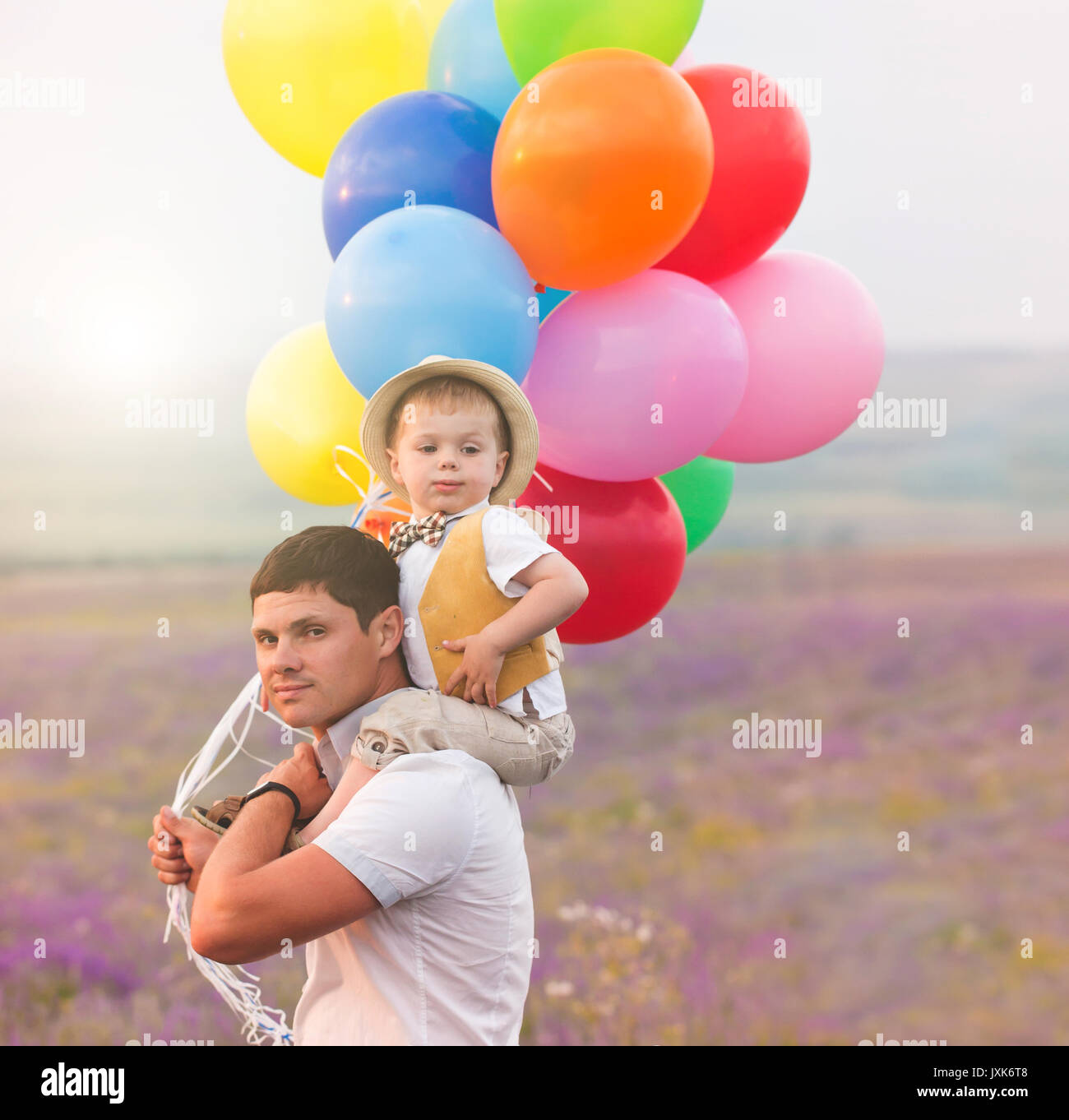 Vater und Sohn spielen mit Ballons auf lavendelfeld Stockfoto