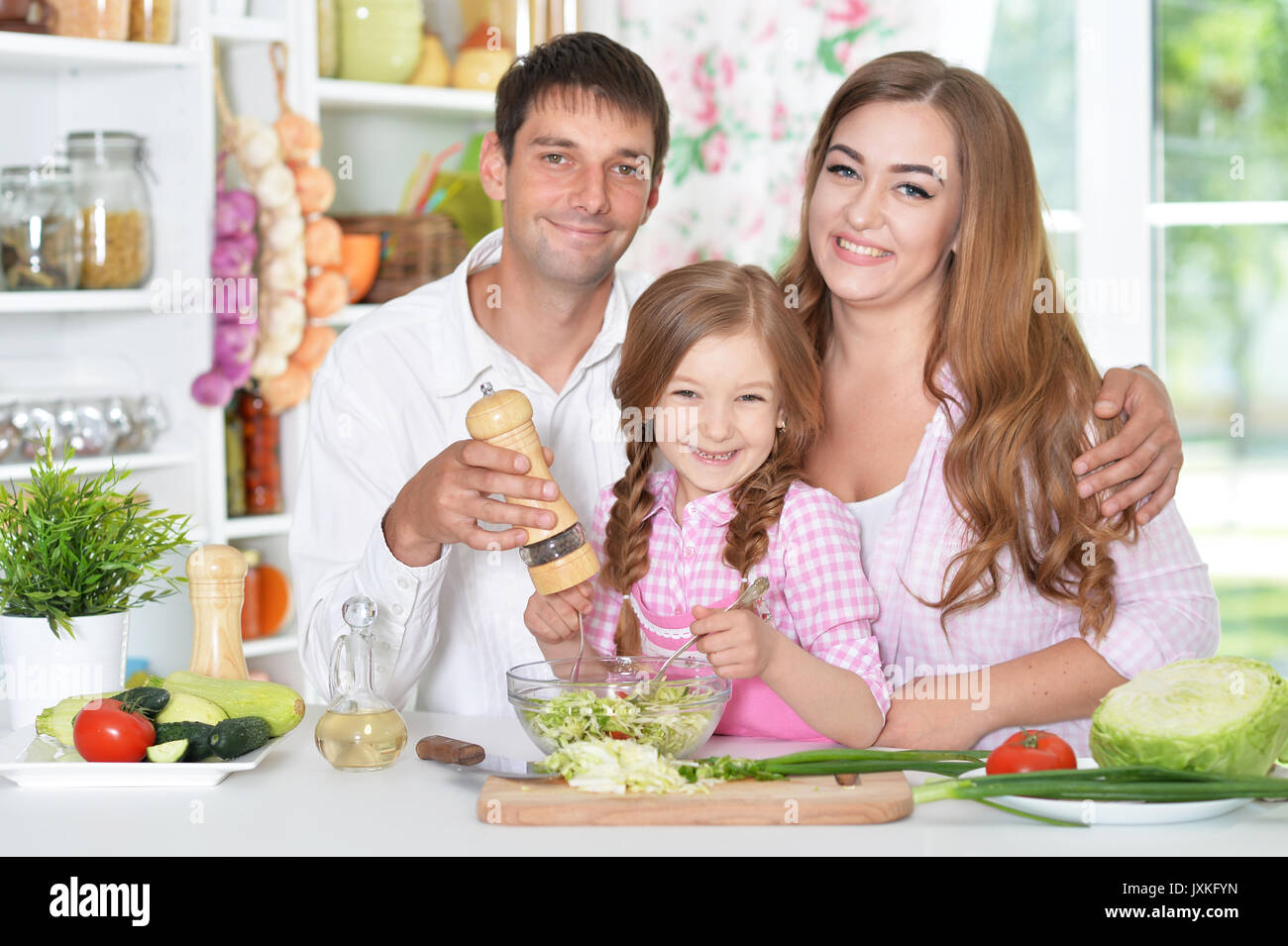 Eltern mit Tochter Vorbereitung Abendessen Stockfoto