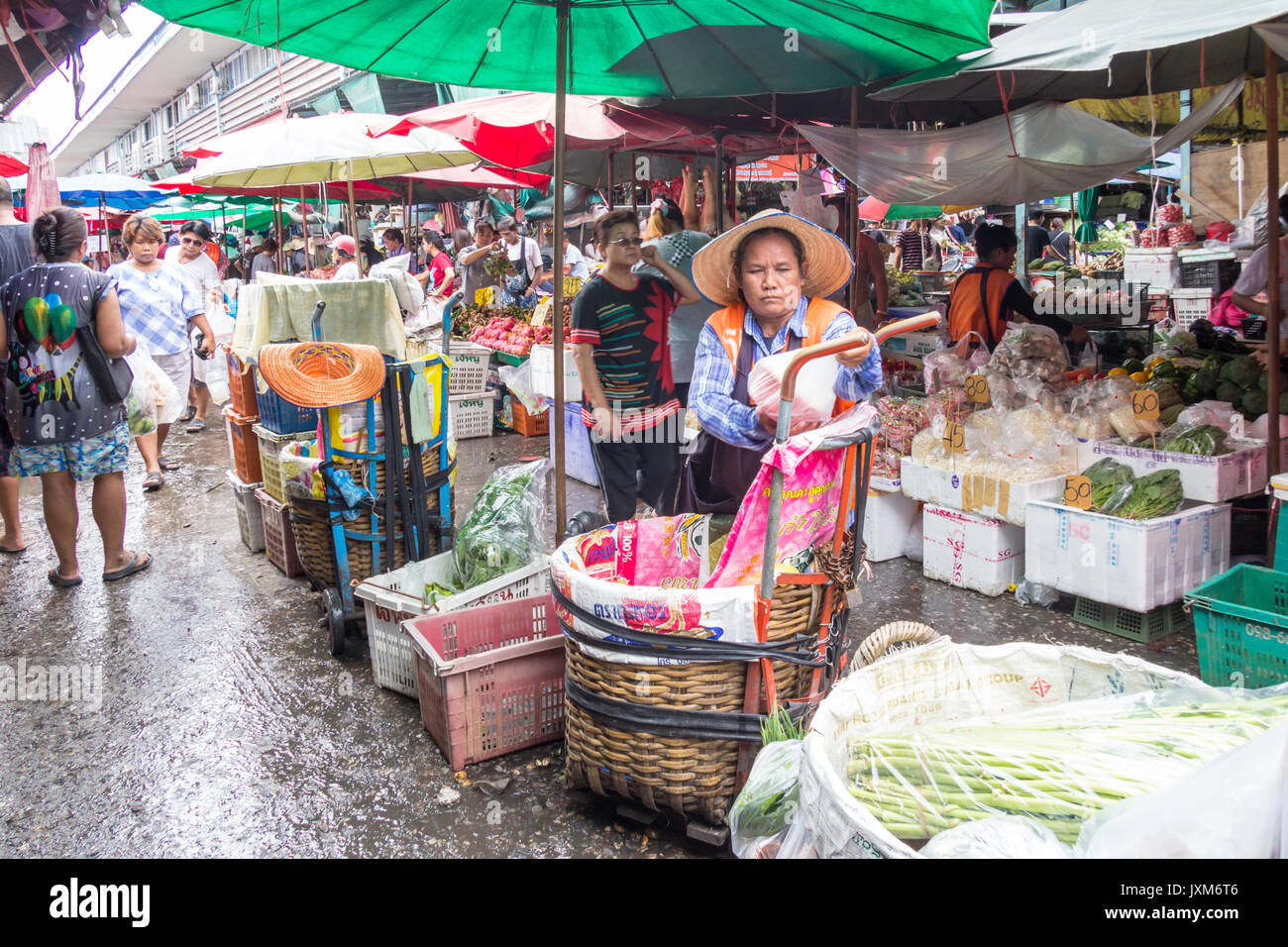 Frau Porter, Kunden und Anbieter am Khlong Toei Wet Market, Bangkok, Thailand Stockfoto