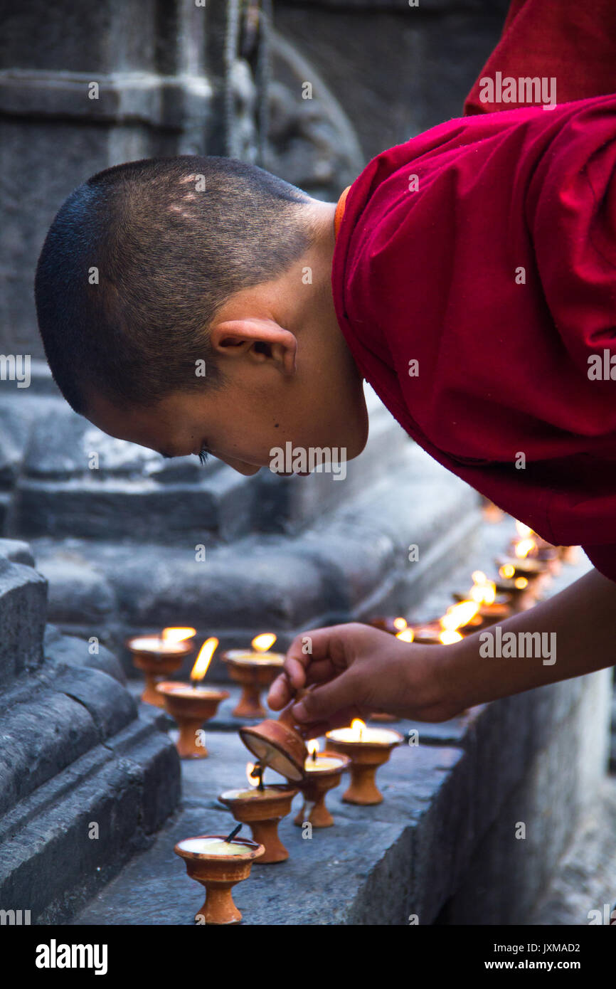Junger buddhistischer Mönch Butterlampen bei Swayambhunath Stupa, auch als der Affe Tempel, in Kathmandu, Nepal bekannt. Stockfoto
