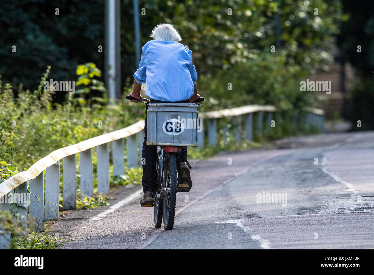 Mann auf einem Fahrrad auf einem Feldweg mit G.B. Aufkleber. Stockfoto