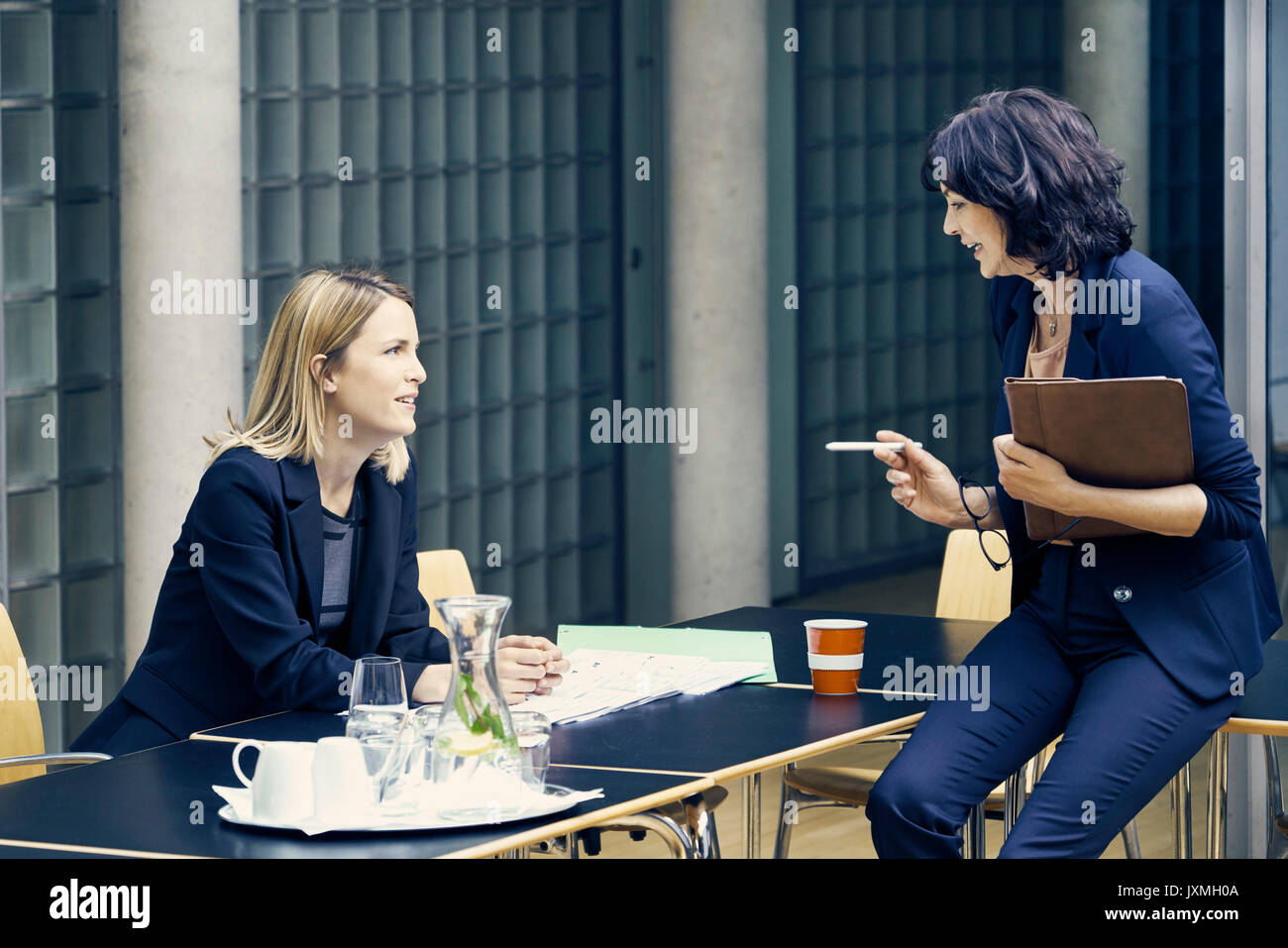 Zwei Geschäftsfrauen in Diskussion am Konferenztisch Stockfoto