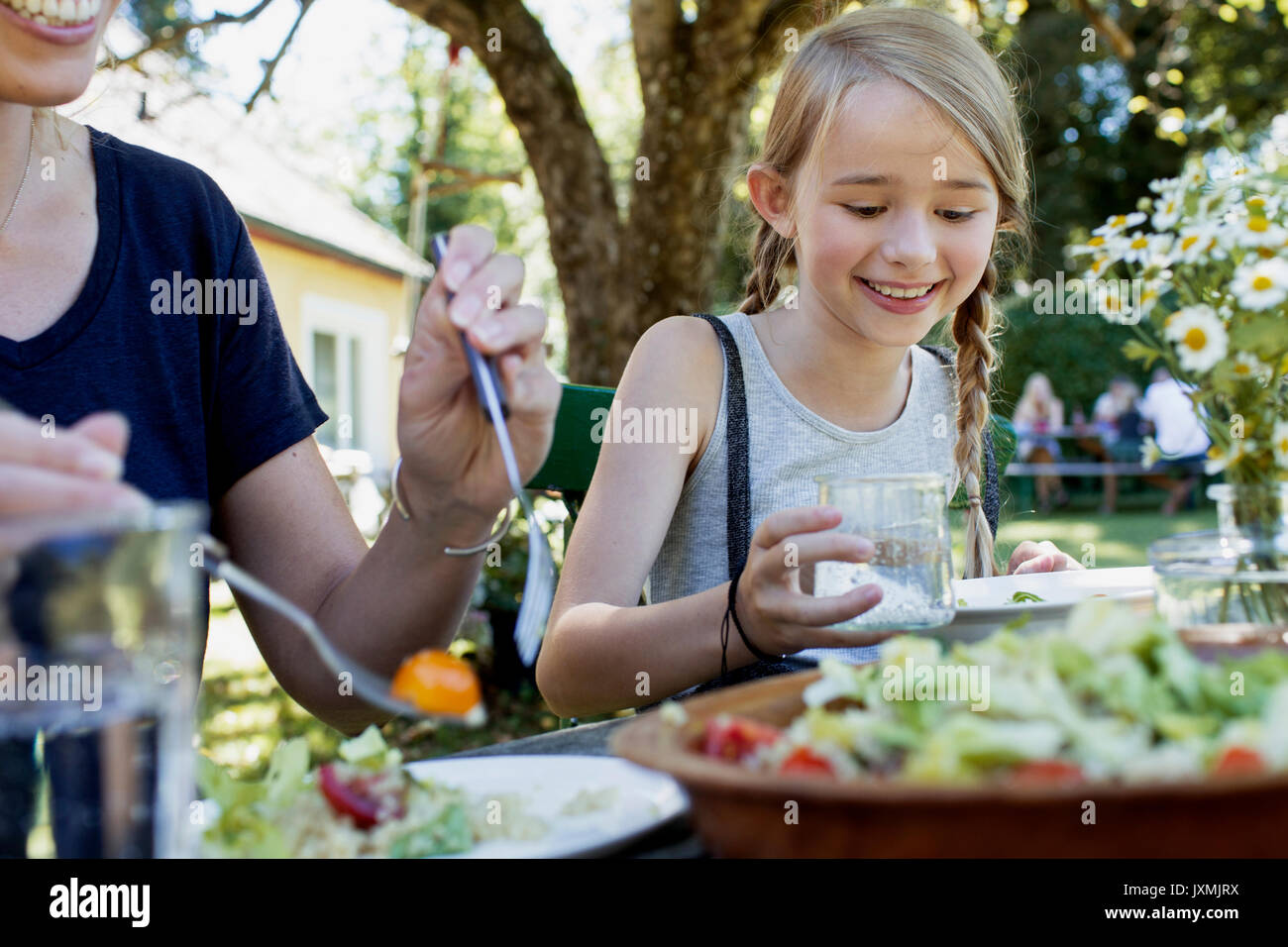 Mutter und Tochter beim Mittagessen im Garten Stockfoto