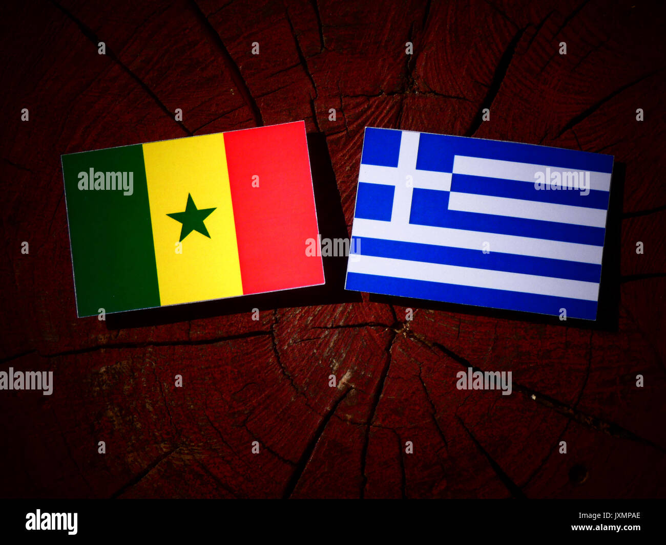 Senegal Fahne mit griechischer Flagge auf einem Baumstumpf isoliert Stockfoto