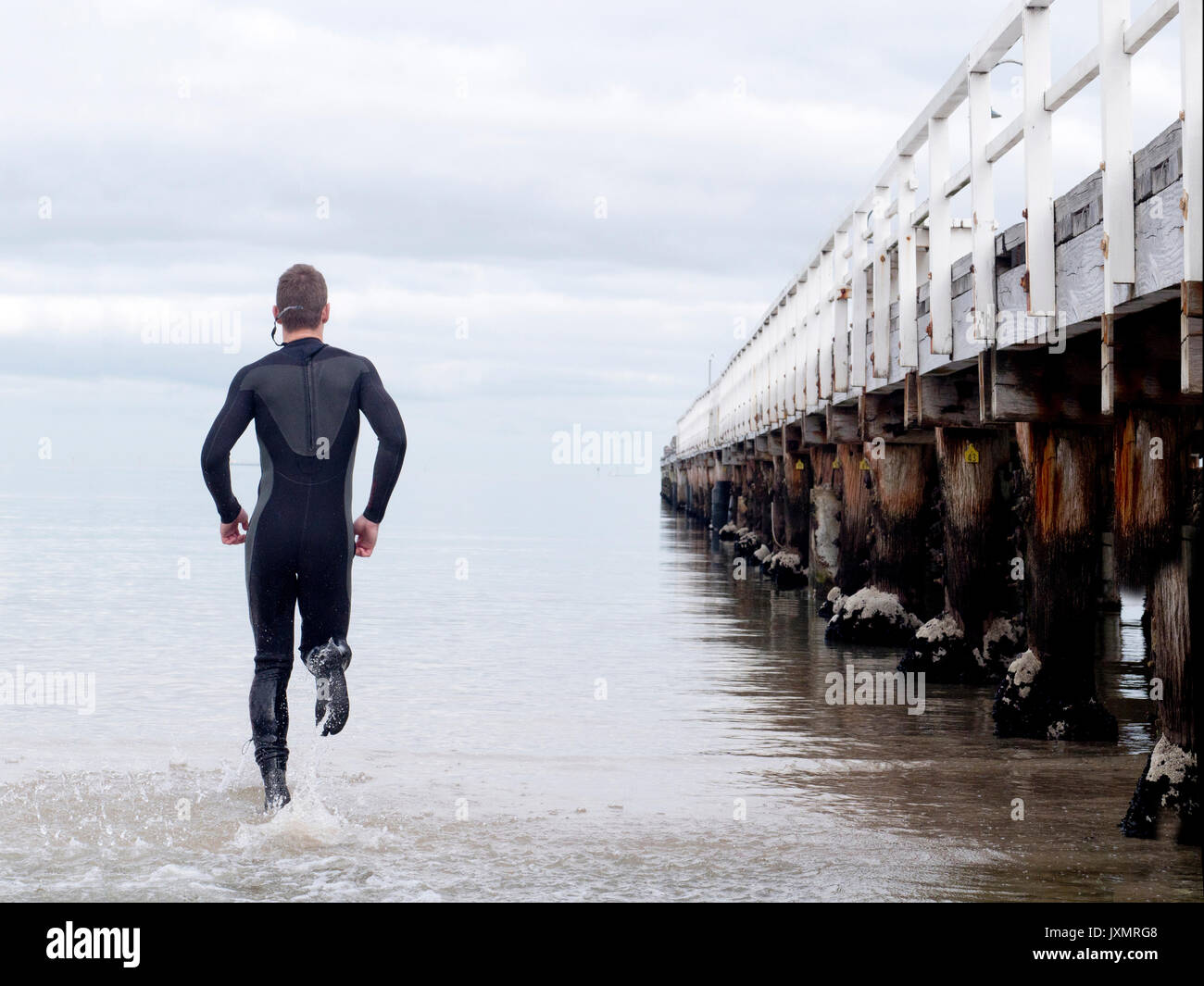 Ansicht der Rückseite des Mann in Anzug ins Meer von Pier, Melbourne, Victoria, Australien, Ozeanien Stockfoto