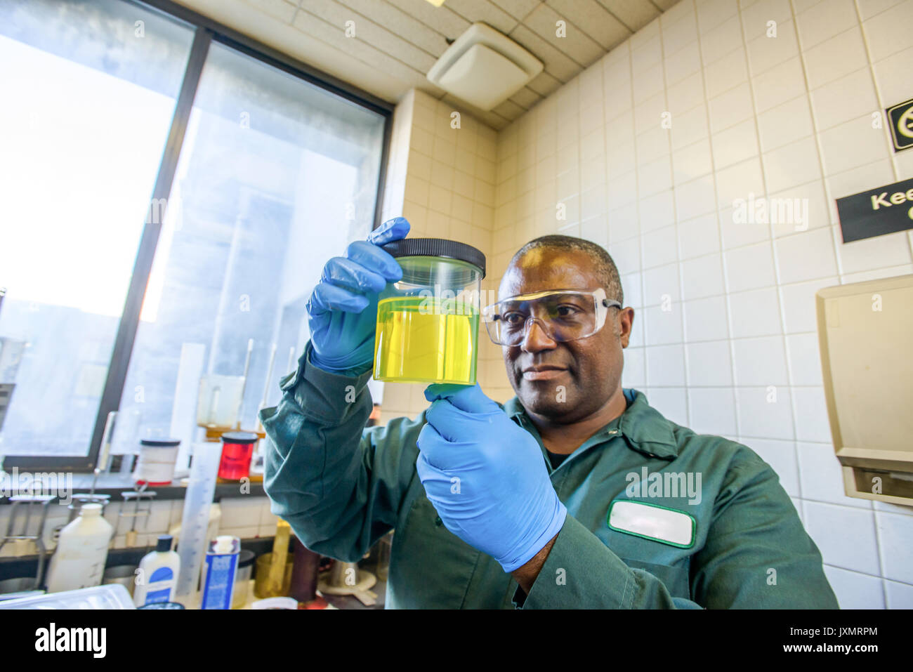 Lab Technician in Becher gelb Biokraftstoff Biokraftstoff anlage Labor Stockfoto