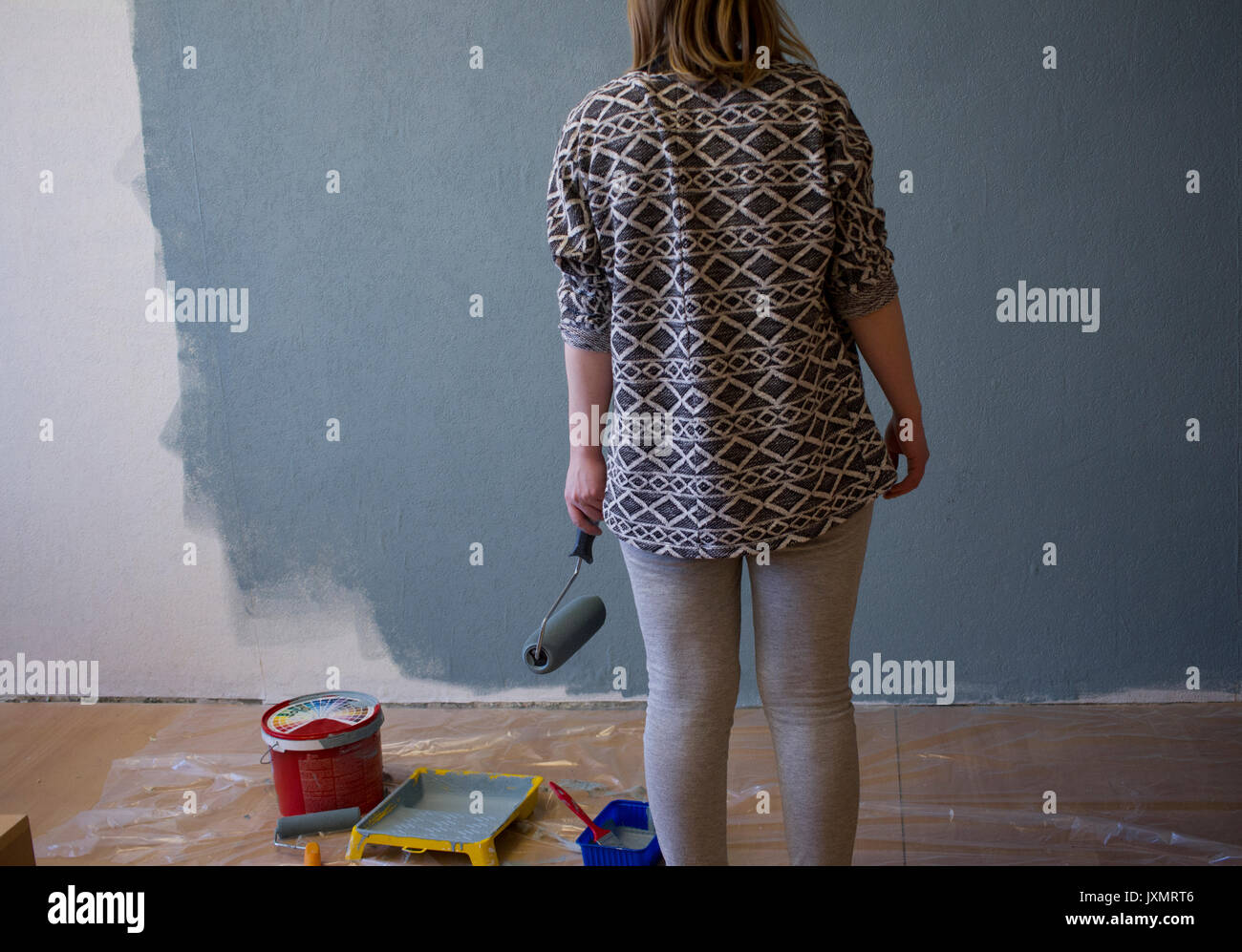 Ansicht der Rückseite des junge Frau Teil grau lackierter Innenraum Wand zu Hause suchen Stockfoto