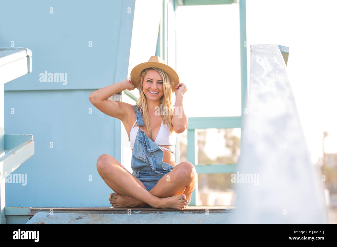 Porträt der jungen Frau gekreuzt auf Beach Hut legged, Santa Monica, Kalifornien, USA Stockfoto