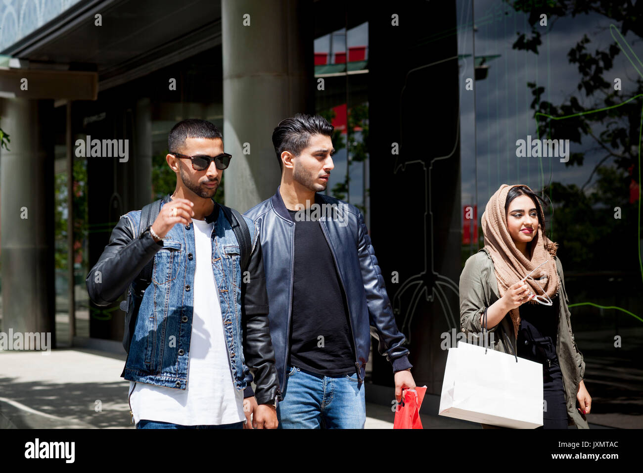Drei Freunde zu Fuß entlang der Straße zusammen Stockfoto