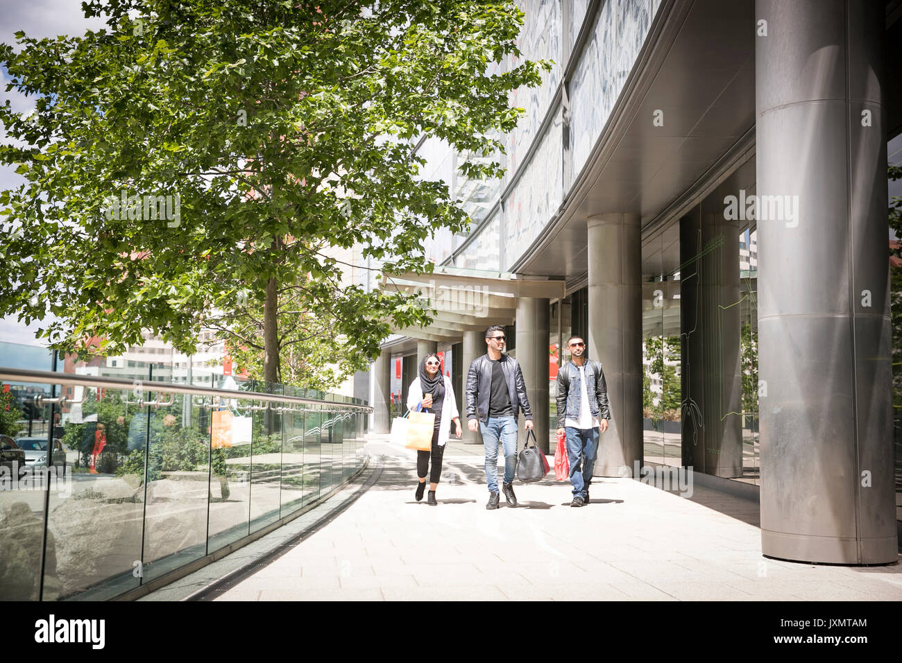 Drei Freunde zu Fuß entlang der Straße zusammen Stockfoto