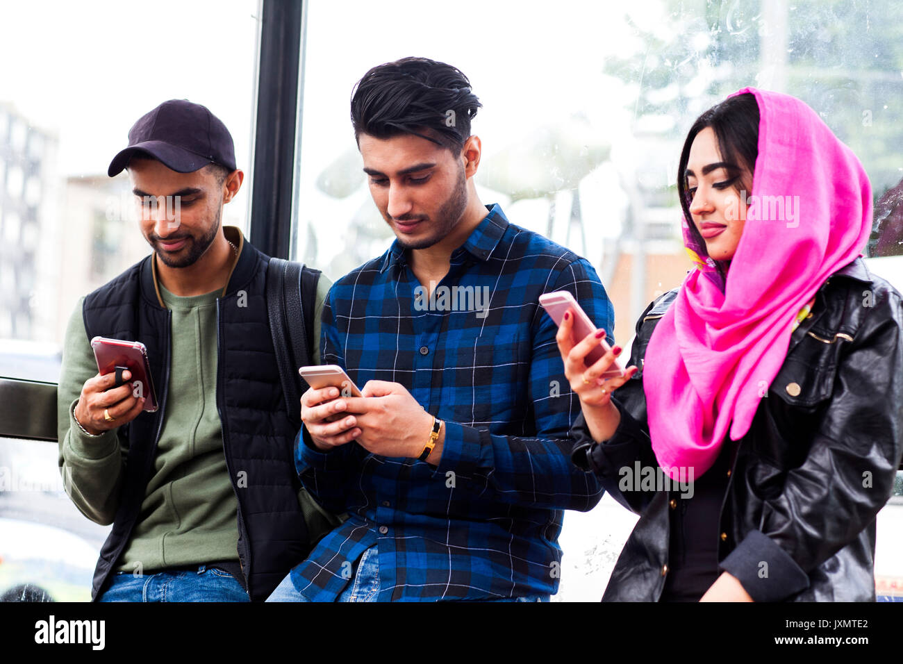 Freunde in einer Reihe alle Blick auf Smartphones Stockfoto