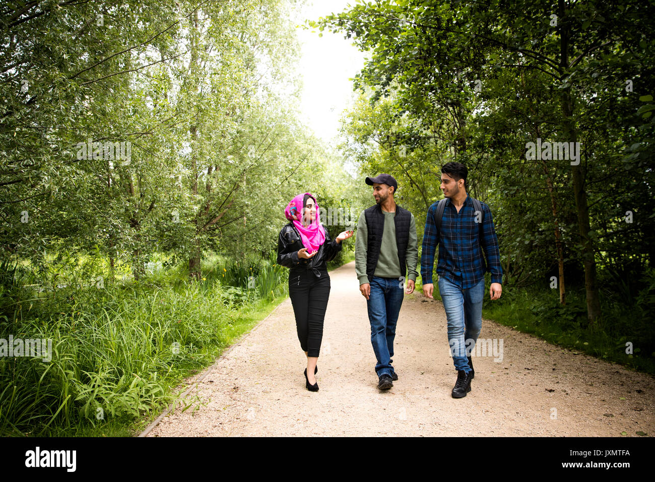 Freunde gehen auf Pathway in Park Stockfoto