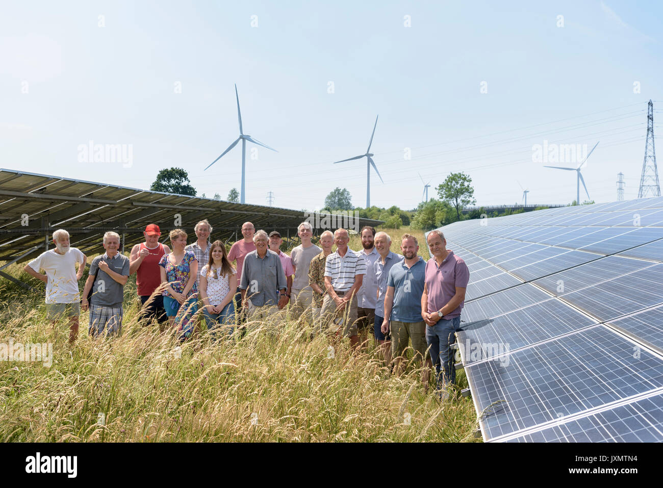 Der Arbeitnehmer der Gemeinschaft durch ihre Solar Farm Stockfoto
