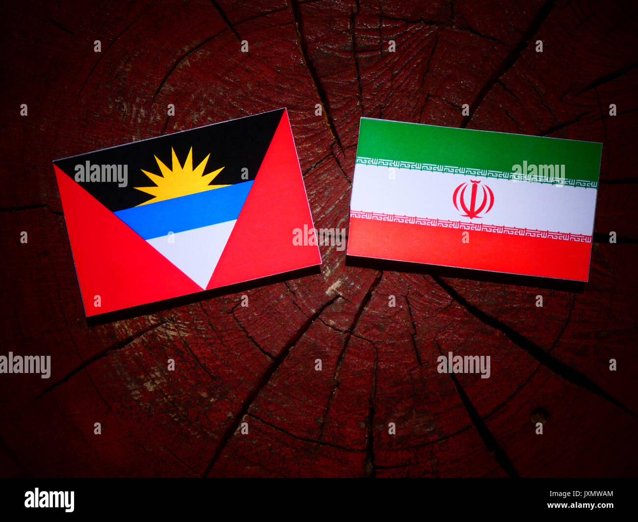 Antigua und Barbuda Flagge mit der Iranischen Flagge auf einem Baumstumpf isoliert Stockfoto