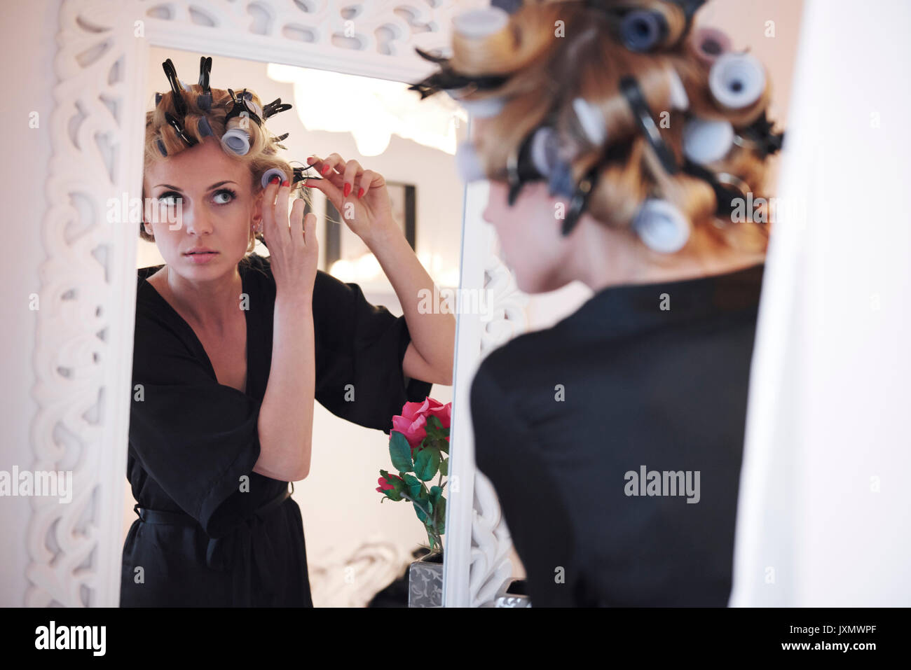 Spiegel Bild der Frau in Haar Rollen Stockfoto