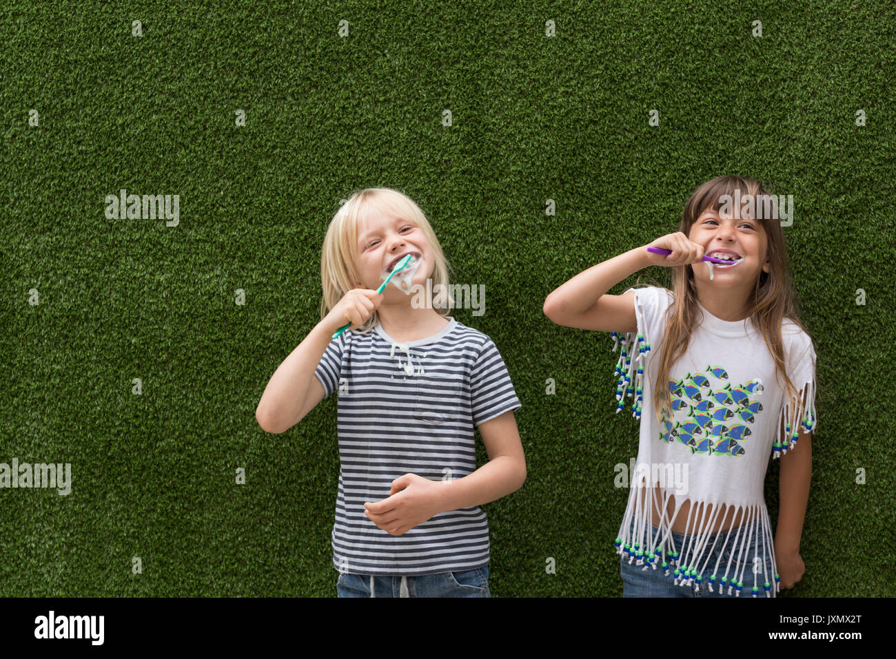 Kinder vor der Kunstrasen wand Zähneputzen Stockfoto