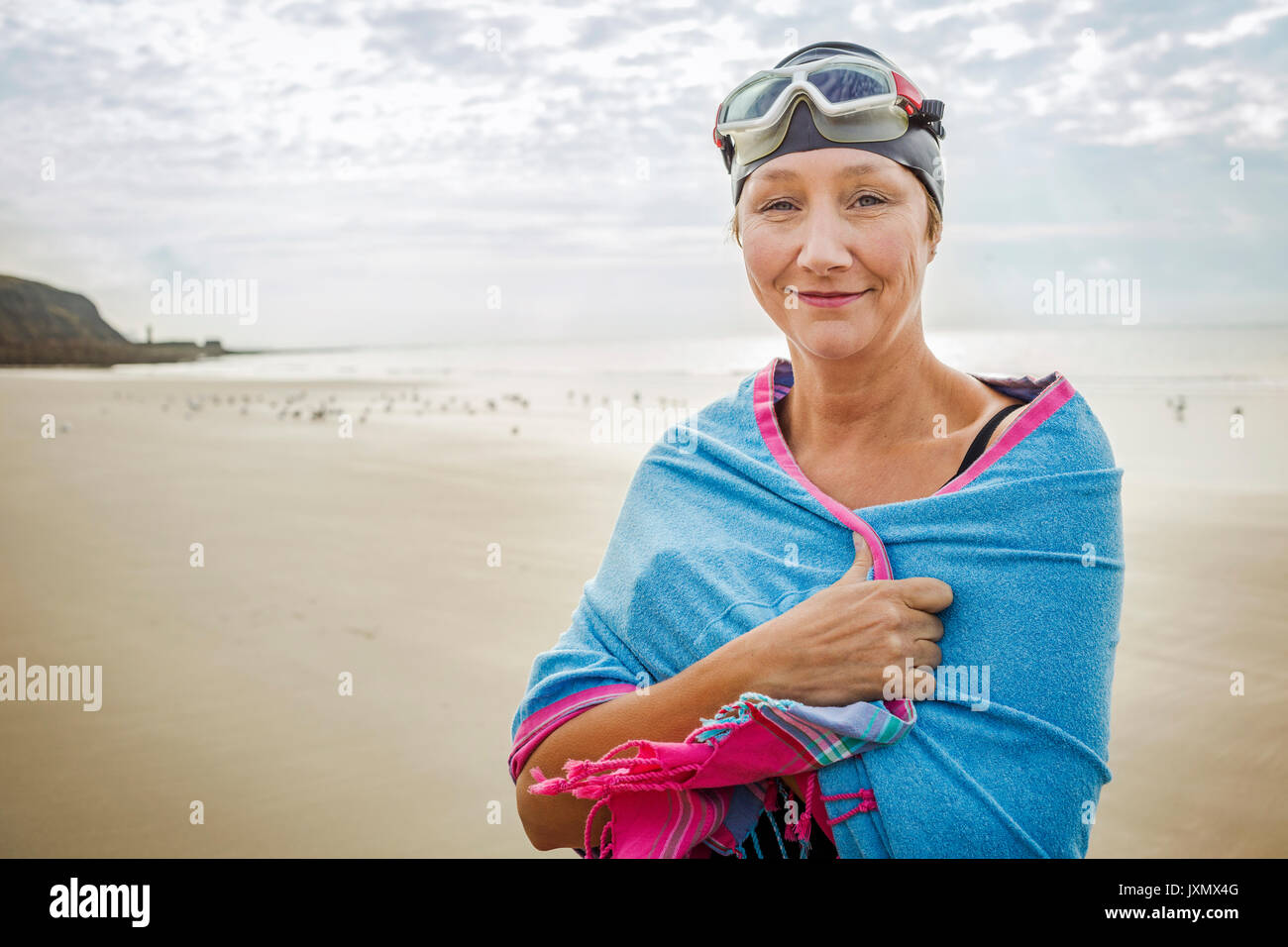 Frau am Strand mit Wrap über Schultern, Folkestone, Großbritannien Stockfoto