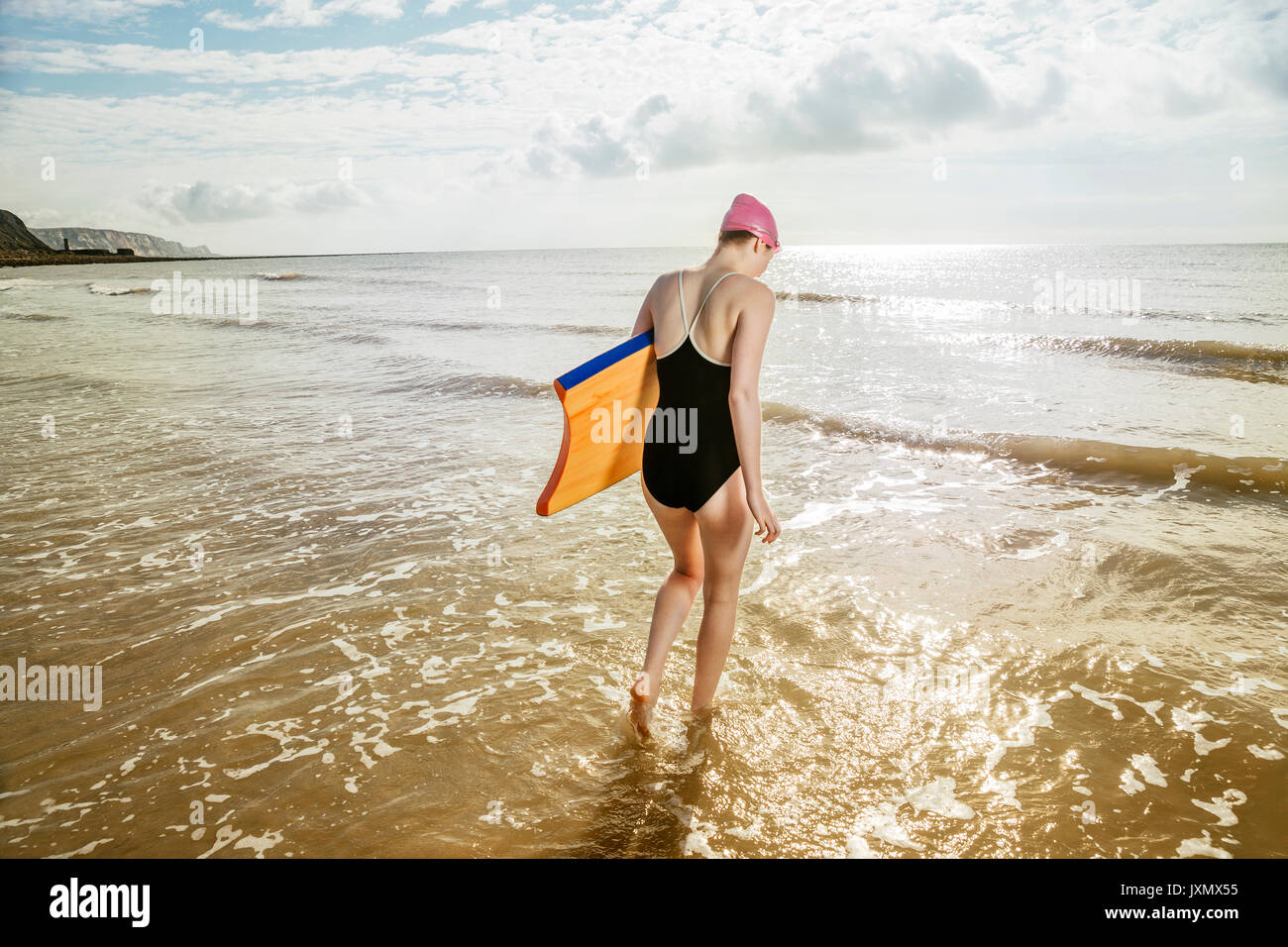Junge Frau Surfbrett im Meer, Folkestone, Großbritannien Stockfoto