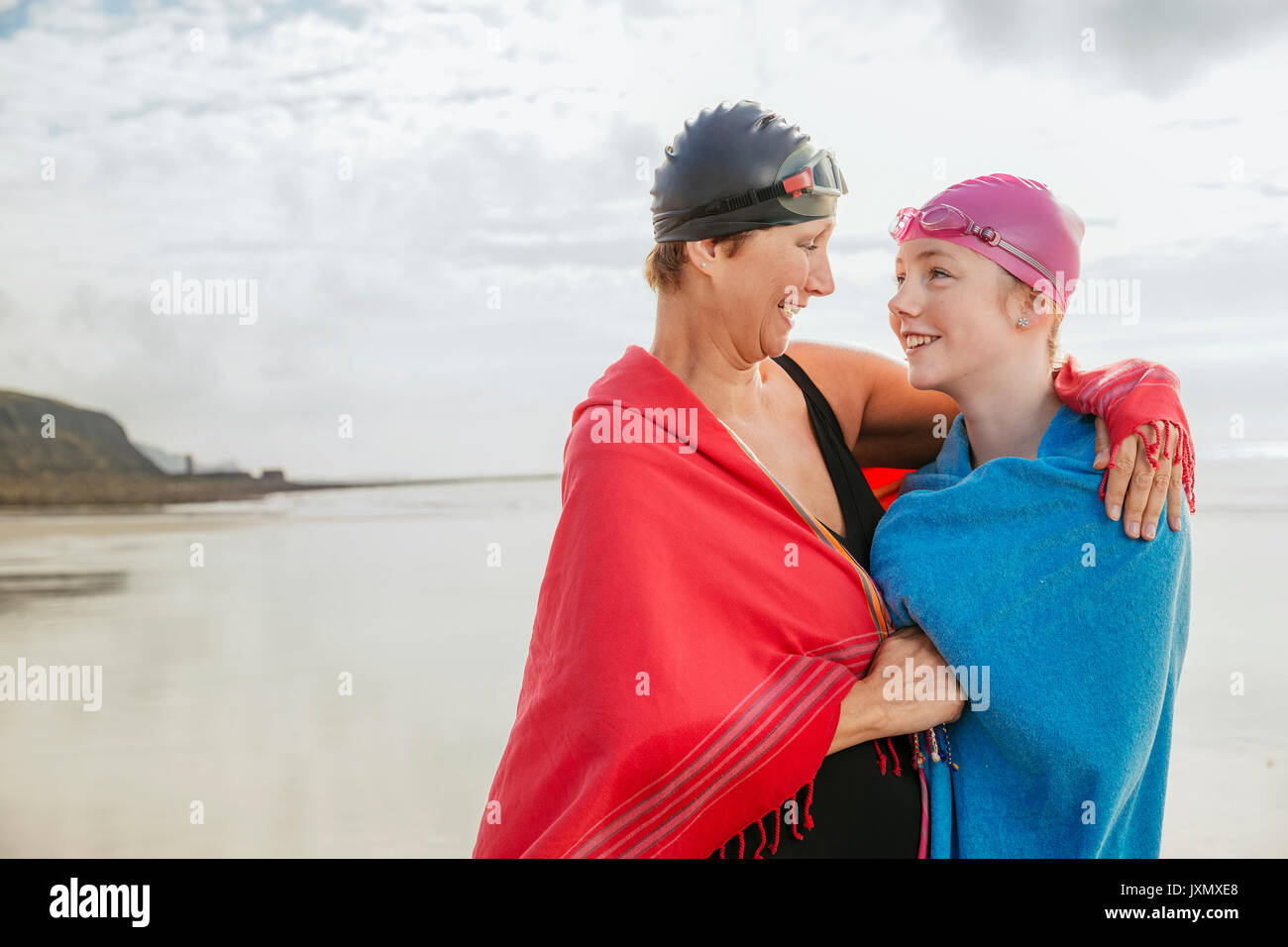 Mutter und Tochter stehen auf Strand mit Schals, Folkestone, Großbritannien Stockfoto