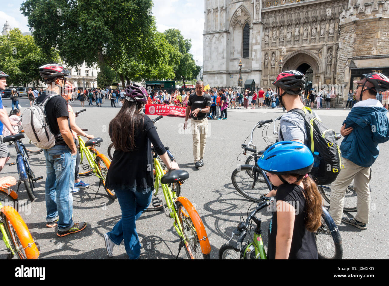 Cycle tour guide seine Gruppe Adressierung außerhalb des Westminster Palace, 20 Dekane Yd, Westminster, London SW1P 3PA, Großbritannien Stockfoto