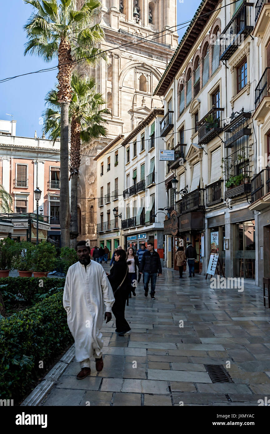 Menschen zu Fuß auf carcel baja Street und Glockenturm, schwarzer Mann in weißen Gewändern auf der Straße, Granada, Andalusien, Spanien Stockfoto