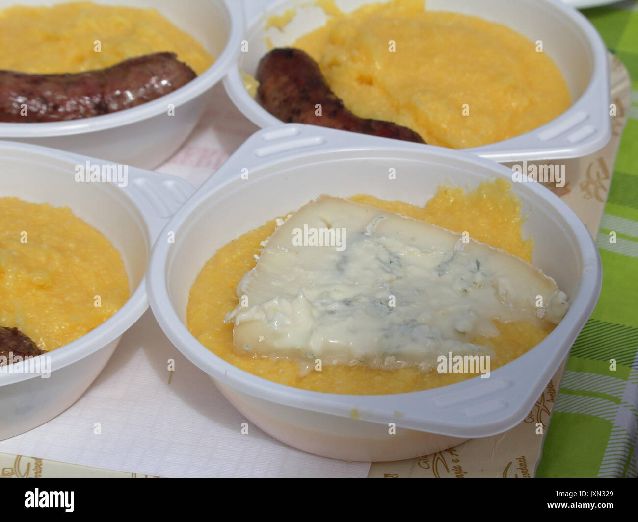 Polenta mit Gorgonzola und gegrillte Würstchen, typische Gerichte der italienischen Küche, serviert in einem Barbecue in Vigezzo Tal, Norditalien Stockfoto