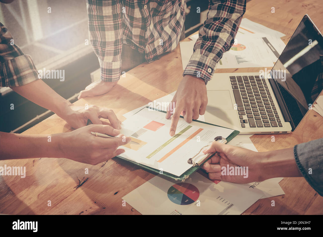 Business Menschen die Hände bei der Arbeit mit finanziellen Plan und auf hölzernen Schreibtisch im Büro, Ansicht von oben geschossen. Die Unterstützung der Gruppe treffen. Stockfoto