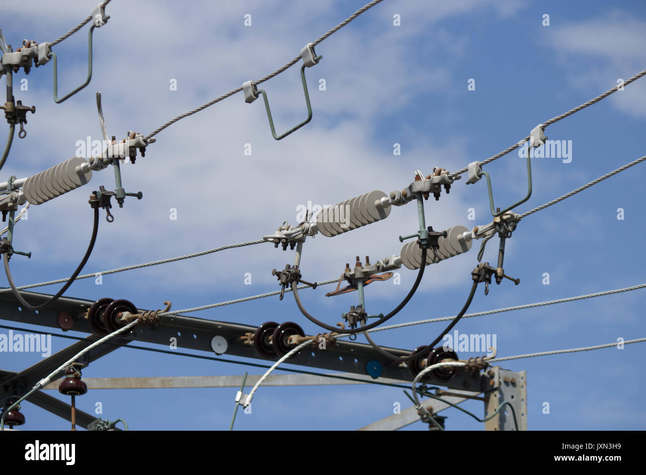 In der Nähe von Hochspannungsleitungen an einem sonnigen Tag mit blauem Himmel und weißen Wolken - Stockfotos Stockfoto