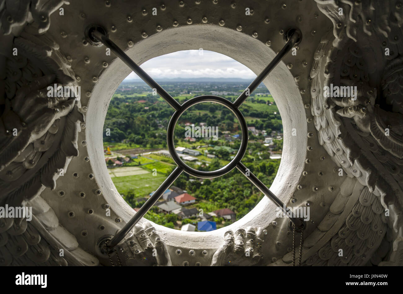 Wat Huai Pla Kung 9 Stufe Tempel, aufwändig verzierte runden Fenster mit Aussicht von der Oberseite des gigantischen chinesischen Stil Buddha Statue, Chiang Rai Thailand Stockfoto