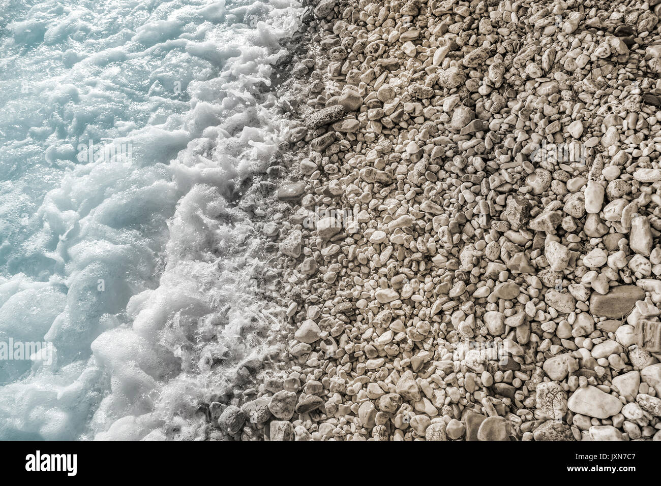 Meer Surfen an einem steinigen Strand. Stockfoto