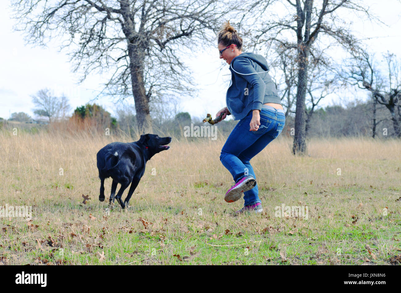 Frau spielen Fetch mit Hund in Weide, authentische aktive Familie Lebensstil mit dem Tier. Stockfoto
