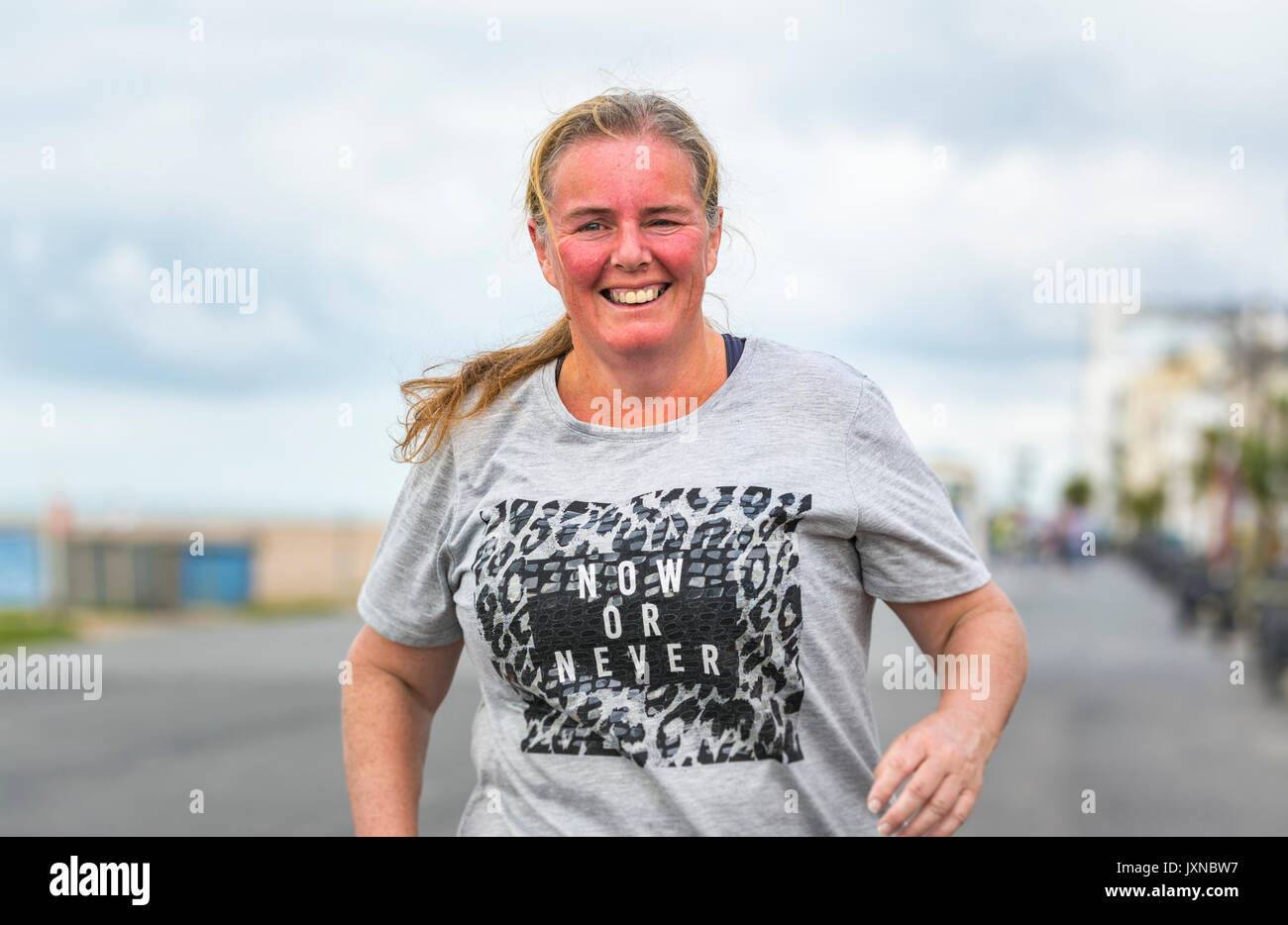 Im mittleren Alter übergewichtig Frau Ausführung als Teil des Plans, um Gewicht zu verlieren und fit, am Worthing Vitalität Parkrun Ereignis. Stockfoto